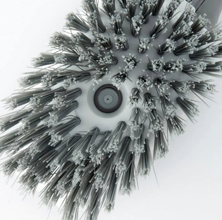 Close-up of a round grey and white cleaning brush head with dense bristles
