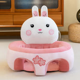 Plush pink and white bunny baby floor seat with cute floral design in a cozy room setting
