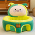 Plush green and yellow pig baby seat with gift box design in a cozy living room