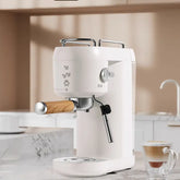 Modern white espresso machine with wood handle on marble kitchen counter, latte nearby