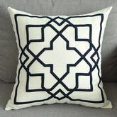 Modern decorative throw pillow with black geometric pattern on a light fabric on gray sofa