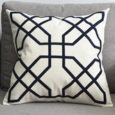 Modern decorative throw pillow with geometric black pattern on white fabric on grey sofa