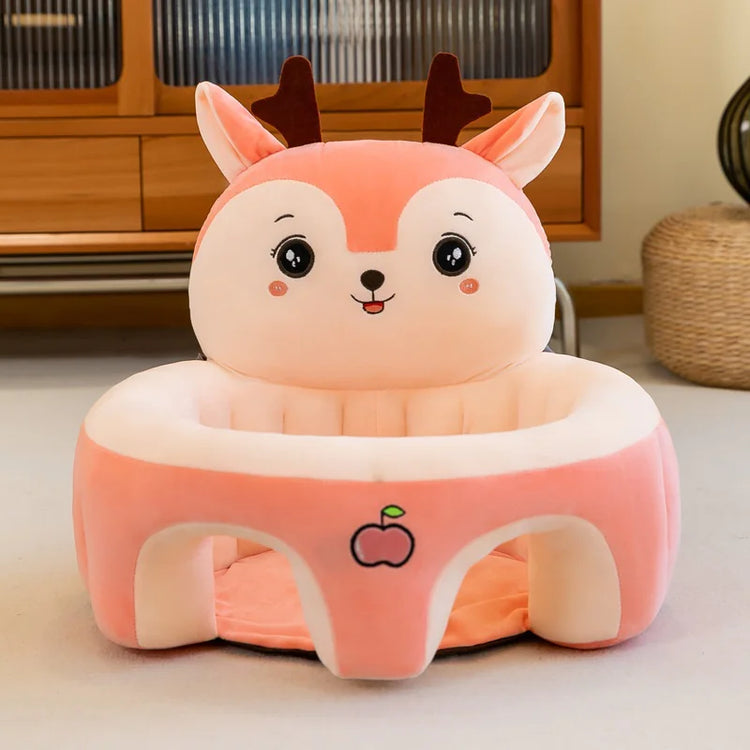 Cute pink deer plush baby seat with embroidered apple in a cozy living room