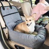 Corgi in a gray quilted car dog seat cover beside a driver in a beige car interior