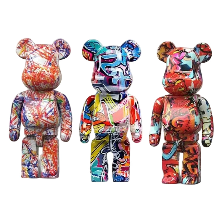 Three colorful graffiti art bear brick figurines on a white surface with a neutral background.