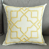 Cream decorative throw pillow with yellow geometric pattern on gray sofa