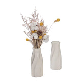 Modern white ceramic vases with dried flowers on a minimal white table