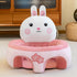 Plush pink bunny baby seat with cherry blossom design on the front, indoor setting