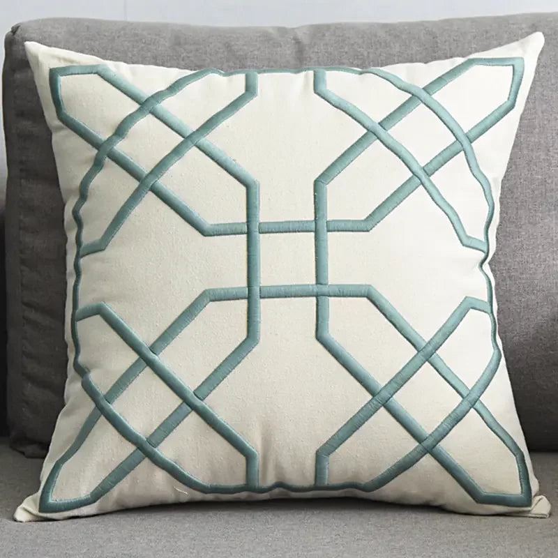 Modern decorative throw pillow with blue geometric pattern on a grey sofa