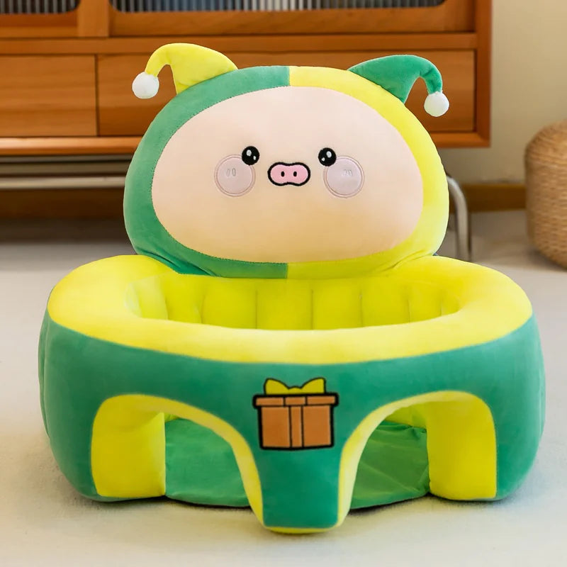 Plush green and yellow pig baby seat with jester hat and gift box design, indoor setting