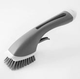 Gray dish scrub brush with soap dispenser and bristles on white background