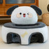 Plush dog-shaped pet bed with cartoon face and gray ears in a cozy room setting